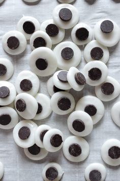 an assortment of white and black fake eyes on a sheet of paper with holes in the middle