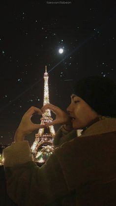 the eiffel tower is lit up at night with stars in the sky above