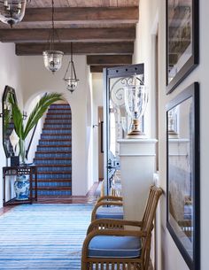 the hallway is decorated with blue and white rugs, wicker chairs, and chandeliers