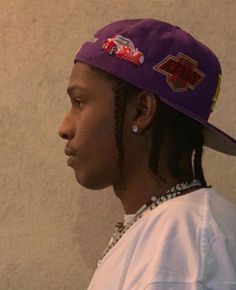 a young man wearing a purple hat with cars on it