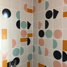 a bathroom with colorful tiles on the wall