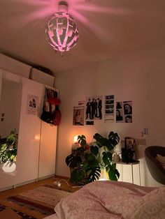 a bedroom with pink lights and pictures on the wall