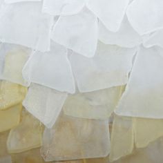 several pieces of white and yellow glass sitting on top of each other