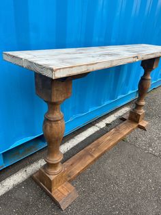 a wooden bench sitting next to a blue container