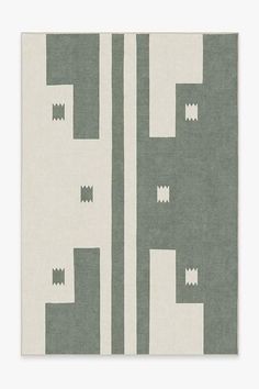 an area rug with grey and white designs on the side, in front of a light gray background