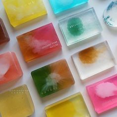 many different colored soaps sitting on top of a white table next to each other