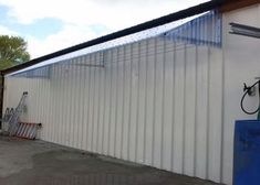 a white building with a blue gas tank next to it