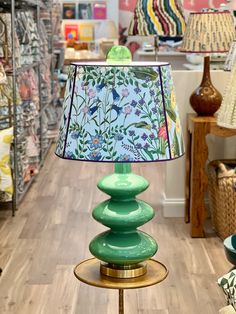 a green lamp sitting on top of a wooden table