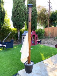 a wooden pole with a towel hanging off it's side in a backyard area