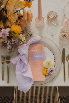 the table is set with an elegant pink and gold place setting, along with silverware