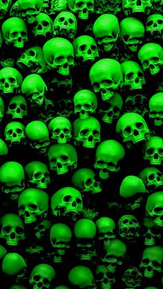 a large group of green skulls are in the dark