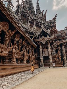 a woman is standing in front of an ornate building