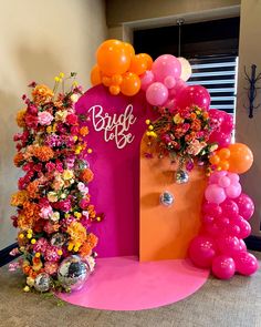 an entrance decorated with flowers and balloons for a bridal party or wedding reception in pink, orange, and yellow