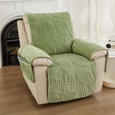 a chair with a green cover on it in front of a fireplace