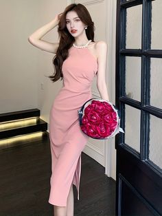 a woman in a pink dress holding a bouquet of roses and posing for the camera