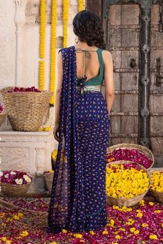 Royal blue saree with all-over floral printed motifs and scallop hem border. Paired with bottle green V-neck blouse. Comes with embroidered belt with bead tassel detailing at hem.
Component: 3
Pattern: Printed, Embroidered
Type Of Work: Floral motifs, Dabka, Sequin work
Neckline: V-neck
Sleeve Type: Sleeveless
Fabric: Georgette
Color: Blue
Other Details: 
U-back blouse
Scallop hem saree
Tassel tie-up detailing
Note: The hairband worn by the model is not for sale.
Occasion: Reception - Aza Fashio Saree Tassel, Royal Blue Saree, Floral Print Saree, Floral Print Sarees, Saree Tassels, Embroidered Belt, Print Saree, Scallop Hem, Blue Saree