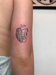 a person with a tattoo on their arm that has a drawing of a human heart