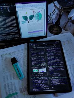 a tablet computer sitting on top of a desk next to a monitor and keyboard with writing on the screen