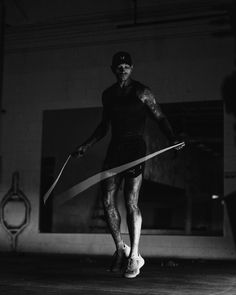 a man holding a pair of scissors while standing on top of a skateboard in a garage