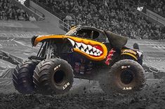 a monster truck with an angry face on it's front tire is going through the mud