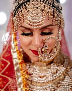 a woman in a bridal outfit with jewelry on her face