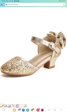 a pair of gold shoes with bows on the toe and heel, all covered in sequins