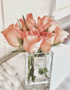 a vase filled with pink roses on top of a table