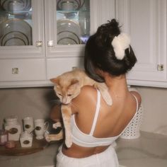 a woman holding a cat in the kitchen