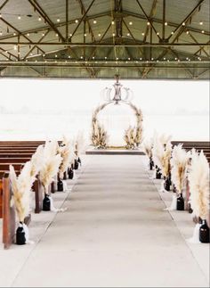 the aisle is decorated with white flowers and feathers