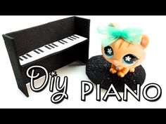 a little doll sitting next to a black piano with the words diy piano on it