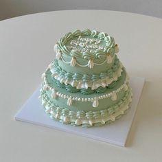 a three tiered cake sitting on top of a white table next to the words feliz cumpleanos domino