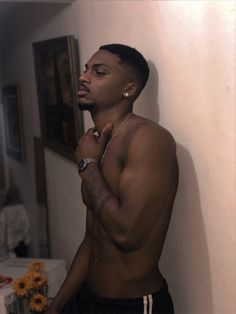 a shirtless man standing in front of a mirror with his hand on his chin