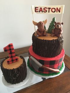 two cakes decorated to look like animals and trees with the number one on top, sitting on a table