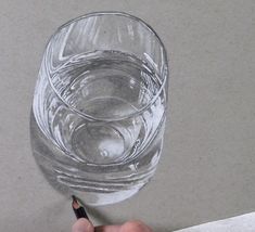 someone is drawing a glass with a pencil