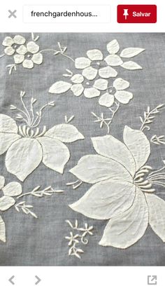 an image of a table cloth with white flowers and leaves on grey background, in french