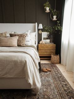 a bedroom with a bed, rug and plants