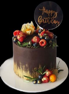 a birthday cake decorated with berries and flowers