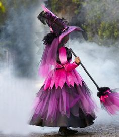 a woman dressed in pink and black holding an umbrella