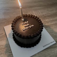 a chocolate cake with a lit candle on top