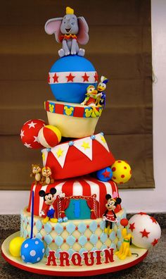 there is a very large cake made to look like an amusement park ride with mickey mouses on top