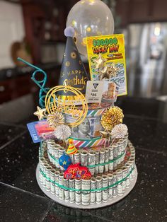 a birthday cake made out of soda cans and other items on a black counter top