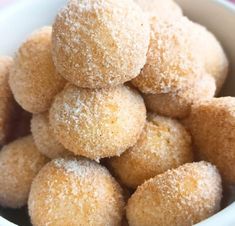 a white bowl filled with sugar covered donuts