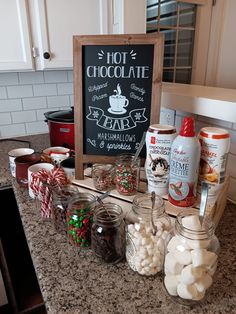 hot chocolates, marshmallows and candy are arranged on the counter top