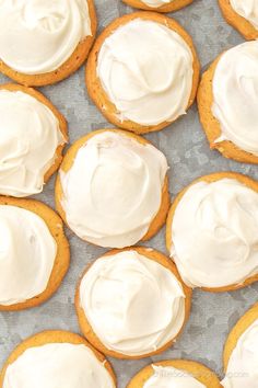 frosted cookies with white icing are on a baking sheet and ready to be eaten