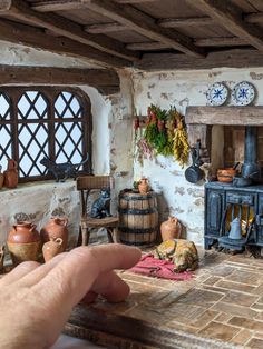 a hand is pointing at an old fashioned kitchen