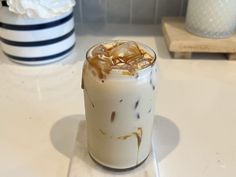 a drink with ice and caramel in it sitting on a counter next to plates