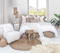 a bedroom with white brick walls and flooring is decorated in neutral tones, such as beige