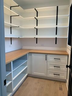 an empty room with white shelves and drawers