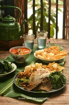 a wooden table topped with plates of food