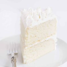 a piece of white cake on a plate with a fork and knife next to it